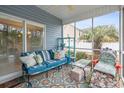 Cozy screened-in porch with colorful furniture, shelving, and a view of a palm tree at 313 Foxpath Loop, Myrtle Beach, SC 29588