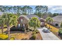 Beautiful aerial view of a brick home with a long driveway, mature landscaping, and a peaceful, tree-lined backdrop at 5508 Leatherleaf Dr., North Myrtle Beach, SC 29582