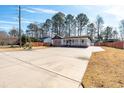 Expansive driveway leading to a charming home with a welcoming porch, surrounded by a well-maintained yard and mature trees at 8533 Cedar Trace Dr., Myrtle Beach, SC 29588