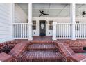 Close-up of the front porch featuring brick steps, white railings, and a stylish front door with decorative glass at 8533 Cedar Trace Dr., Myrtle Beach, SC 29588