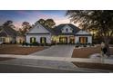 Charming single-story home featuring a manicured lawn and brick paver driveway at twilight at 1109 Wigeon Dr., Conway, SC 29526