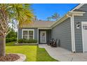 Charming single-story home with walkway to front door, tidy landscaping, and inviting front porch with chairs at 1118 Prescott Circle, Myrtle Beach, SC 29577