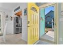 Inviting entryway with a bright yellow door and a view into the kitchen with stainless steel appliances at 1607 Havens Dr., North Myrtle Beach, SC 29582