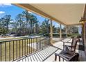 Inviting covered front porch with brick flooring, black railing, and comfortable seating at 4350 Goude St., Murrells Inlet, SC 29576