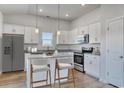 Bright kitchen features white cabinetry, stainless steel appliances, granite countertops and an island with bar seating at 491 Wagner Cir., Conway, SC 29526