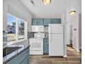 Bright kitchen featuring white appliances, blue cabinets, granite countertops and wood-look vinyl floors at 610 15Th Ave. S # 1, Surfside Beach, SC 29575