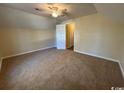 A bedroom with neutral carpet and walls, ceiling fan, and an open doorway at 1000 Weldon Ln., Conway, SC 29526