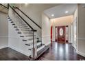 Bright foyer features hardwood floors, a staircase with white railing, and a decorative wood front door at 1585 Brookgreen Dr., Myrtle Beach, SC 29577