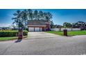 Side view of brick house, showcasing a three-car garage with spacious driveway and manicured lawn at 1585 Brookgreen Dr., Myrtle Beach, SC 29577