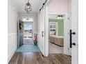 Inviting foyer with hardwood floors, an open door, and a view into a bedroom with a ceiling fan at 3105 White Jasmine Dr., Little River, SC 29566