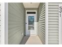 Front door with glass, number 591, and neutral siding for a clean and welcoming entrance at 591 Meadowgrass Ct., Myrtle Beach, SC 29588