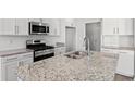 Modern kitchen features stainless steel appliances, granite countertops, and white cabinets at 1206 Cypress Shoal Dr., Conway, SC 29526