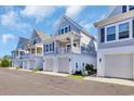 Charming coastal homes feature covered garages and inviting balconies on a bright, sunny day at 138 Marblehead Dr., Little River, SC 29566