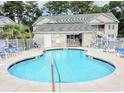 Sparkling outdoor pool with lounge chairs, a covered area, and well-maintained surroundings at 160 Lazy Willow Ln. # 204, Myrtle Beach, SC 29577