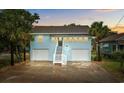 Charming light blue two-story home with dual garage, stairway entry, and mature palm trees at 214 2Nd Ave. S, North Myrtle Beach, SC 29582