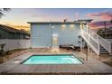Backyard featuring a pool with lounge area, steps to second floor and white privacy fence at 214 2Nd Ave. S, North Myrtle Beach, SC 29582