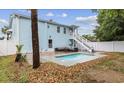 Backyard featuring a pool with lounge area, steps to second floor and white privacy fence at 214 2Nd Ave. S, North Myrtle Beach, SC 29582
