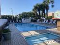 Outdoor pool and hot tub area with lounge chairs and surrounding greenery under a clear sky at 2708 S Ocean Blvd. S # 302, Myrtle Beach, SC 29577