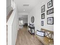 Inviting foyer with wood-look floors, staircase, and decorative bench with Gathering photos at 283 Marauder Dr., Longs, SC 29568