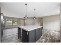 Open-concept kitchen with a large center island, modern pendant lighting, and stainless steel appliances at 3685 Nichols Hwy., Aynor, SC 29511