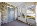 Cozy sunroom boasts a brick wall, large windows, and a screen door leading to the outdoors at 3936 Tybre Downs Circle # 3936, Little River, SC 29566