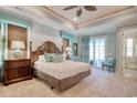 Spacious main bedroom with a king bed, balcony, and a view into the main bath with tiled shower at 4934 Salt Creek Ct., North Myrtle Beach, SC 29582