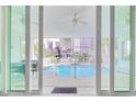 View of sparkling pool and resort through sliding glass doors from covered veranda with ceiling fans at 4934 Salt Creek Ct., North Myrtle Beach, SC 29582