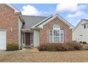 Traditional-style brick home showcasing a front entry, shutters, and manicured landscaping at 5077 Capulet Circle, Myrtle Beach, SC 29588