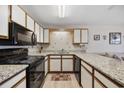 Modern kitchen featuring granite countertops, white cabinets, and black appliances at 510 Fairwood Lakes Ln. # 20E, Myrtle Beach, SC 29588