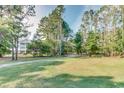 Lush grassy view of the community with mature trees and the condo building in the distance at 5825 Catalina Dr. # 531, North Myrtle Beach, SC 29582
