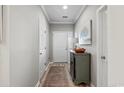 A bright, neutral foyer showcasing wood-look floors, a decorative cabinet, and white trim at 5834 Longwood Dr. # 303, Murrells Inlet, SC 29576