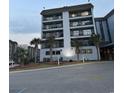 Multi-story condo building showcasing a light blue facade, multiple balconies, and palm trees at 5905 S Kings Highway # B-455, Myrtle Beach, SC 29588