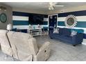 Cozy living room features stylish striped walls, comfortable seating, and a ceiling fan at 5905 S Kings Highway # B-455, Myrtle Beach, SC 29588