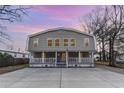 Two story house with a front porch and American flag and large concrete driveway at 613 Calhoun Dr., Murrells Inlet, SC 29576