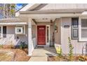 Inviting front porch featuring a red door and homey decorations and a covered entry way at 6634 Cinnamon Fern Ln., Myrtle Beach, SC 29588