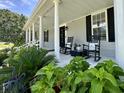 Inviting front porch featuring rocking chairs, white columns, and lush landscaping for relaxation at 6636 Breezewood Blvd., Myrtle Beach, SC 29588
