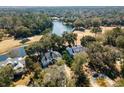 Expansive aerial view of a luxury home with a pool, set amidst lush greenery and a tranquil lake at 1046 Wallace Pate Dr., Georgetown, SC 29440