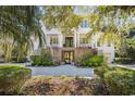Elegant white home featuring a brick facade, stately columns, manicured greenery, and a welcoming entrance at 1046 Wallace Pate Dr., Georgetown, SC 29440