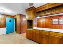 Vintage kitchen with wood cabinets, a pass-through to living room and unique blue door at 1206 French Rd, Mullins, SC 29574