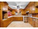 Vintage kitchen featuring wood-paneled walls and cabinets, a ceiling fan and a window over the sink at 1206 French Rd, Mullins, SC 29574