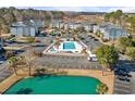 Aerial view of the neighborhood featuring a community pool and a pond with ample parking spaces at 1282 River Oaks Dr. # 9F, Myrtle Beach, SC 29579