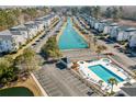 Overhead angle of a community with a pool and water feature flanked by condo buildings and parking at 1282 River Oaks Dr. # 9F, Myrtle Beach, SC 29579