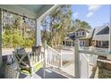 Inviting front porch featuring comfortable seating and views of the landscaped front yard and charming home at 136 Da Gullah Way # A, Pawleys Island, SC 29585