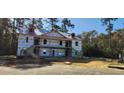 New home construction showcases two-story design with porch, stairs and trees surrounding at 1407 Gooseneck Place # 202, Murrells Inlet, SC 29576
