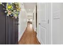 Hallway featuring wood floors, white trim, and a view leading into a naturally lit living space at 1487 Lanterns Rest Rd. # 4, Myrtle Beach, SC 29579