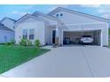 Attached garage with white car parked inside, lawn and landscaped front yard at 177 Fox Rae Dr., Conway, SC 29526