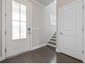Bright foyer featuring a glass-paneled front door, hardwood floors, and staircase leading to the upper level at 1808 Zodiac Court, Myrtle Beach, SC 29577