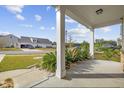 Charming covered front porch with white columns and lush landscaping, offering a welcoming entrance to the home at 1808 Zodiac Court, Myrtle Beach, SC 29577