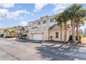 View of attached garage in a condo building with ample parking, a balcony, and palm tree landscaping at 2180 Waterview Dr. # 727, North Myrtle Beach, SC 29582