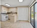 Bright kitchen featuring white appliances, tile floors, ample cabinet space, and a sliding door to the outdoor area at 306 74Th Ave. N # 105, Myrtle Beach, SC 29572